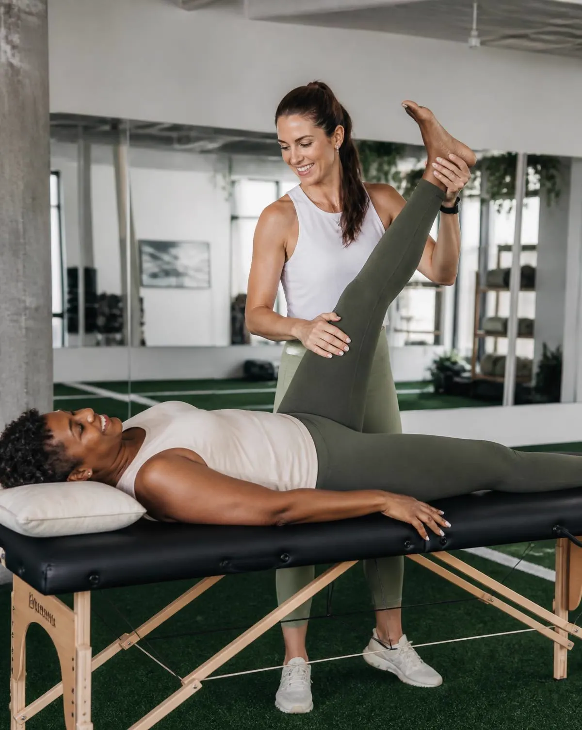 Practitioner guiding an older woman through an assisted shoulder stretch
