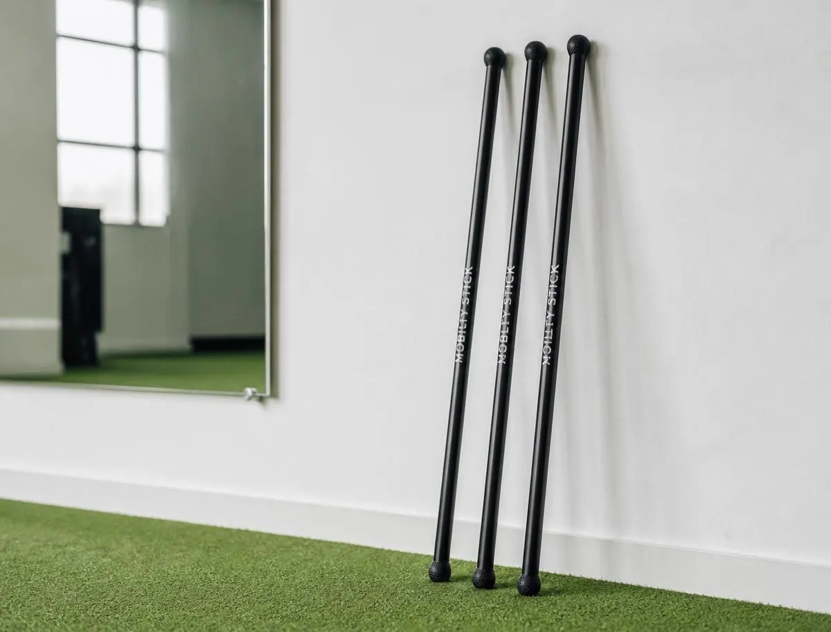 Mobility sticks resting against the studio wall on turf flooring